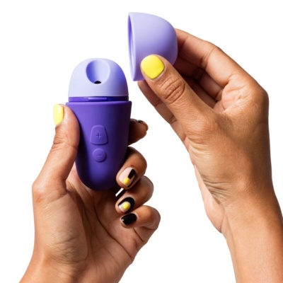 Dispositivo pequeno roxo com botões segurado por mãos com unhas pintadas