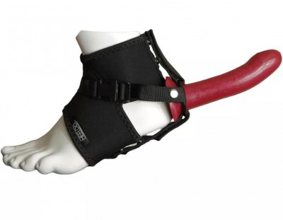 Ardil com cinta preta e dildo vermelho num pé manequim branco