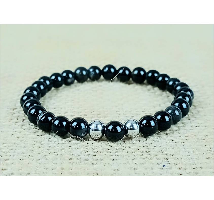 Pulseira da Prudência - Ágata Preta Riscada Pulseira de contas pretas com três contas prateadas no centro sobre tecido bege