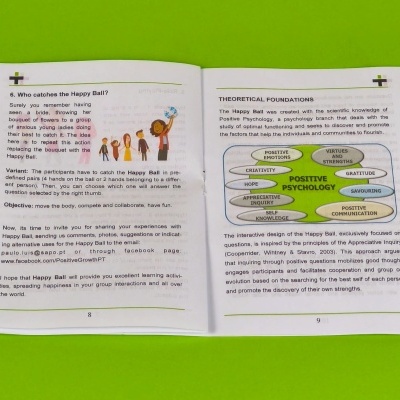 Livro aberto com texto em inglês sobre psicologia positiva e Happy Ball