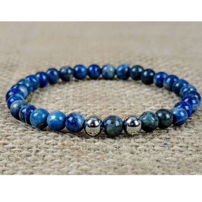 Pulseira de contas azuis e prateadas sobre tecido bege