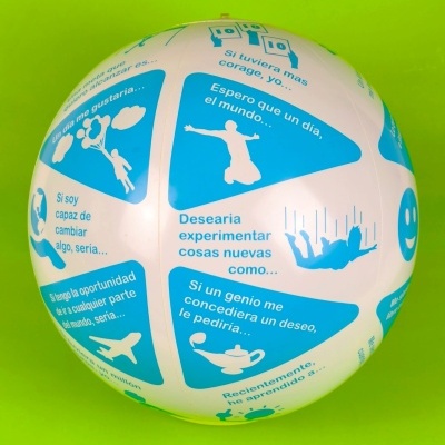 Bola branca com painéis azuis e texto em espanhol sobre fundo verde