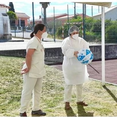 Grupo de profissionais de saúde ao ar livre com bola azul e branca