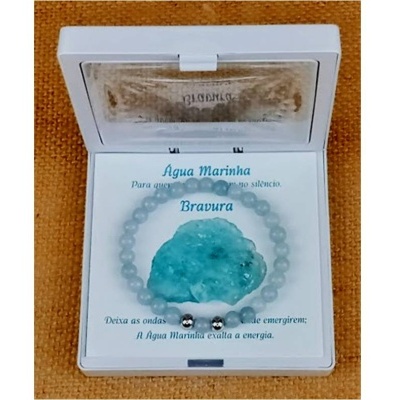 Pulseira azul clara com pedra bruta em caixa branca com texto em português