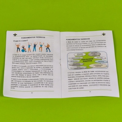 Livro aberto explicando fundamentos do lazer e psicologia positiva com ilustrações e diagrama colorido em fundo verde