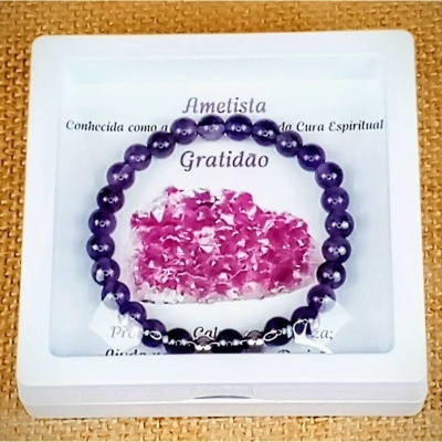 Pulseira de contas de ametista roxa numa caixa branca com mensagem e coração de pétalas rosas