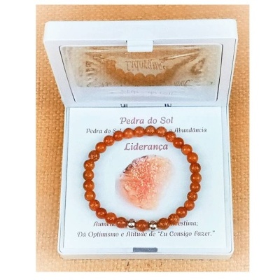 Pulseira de pedra do sol laranja em estojo branco com texto explicativo