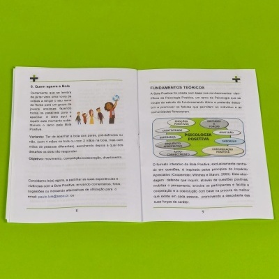 Livro aberto com texto e ilustrações sobre Psicologia Positiva sobre fundo verde