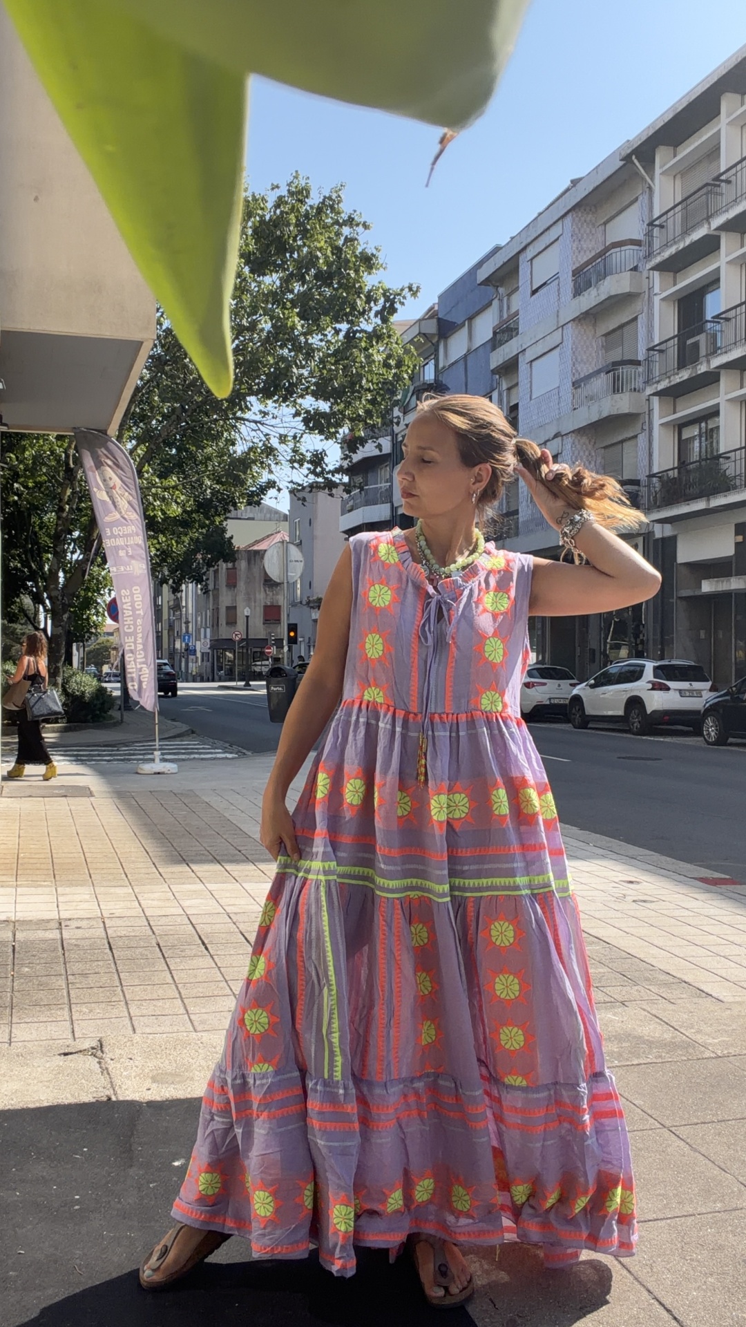 Vestido Boho Chic Fluo Vestido comprido lilás com padrões florais neón usado por mulher na rua
