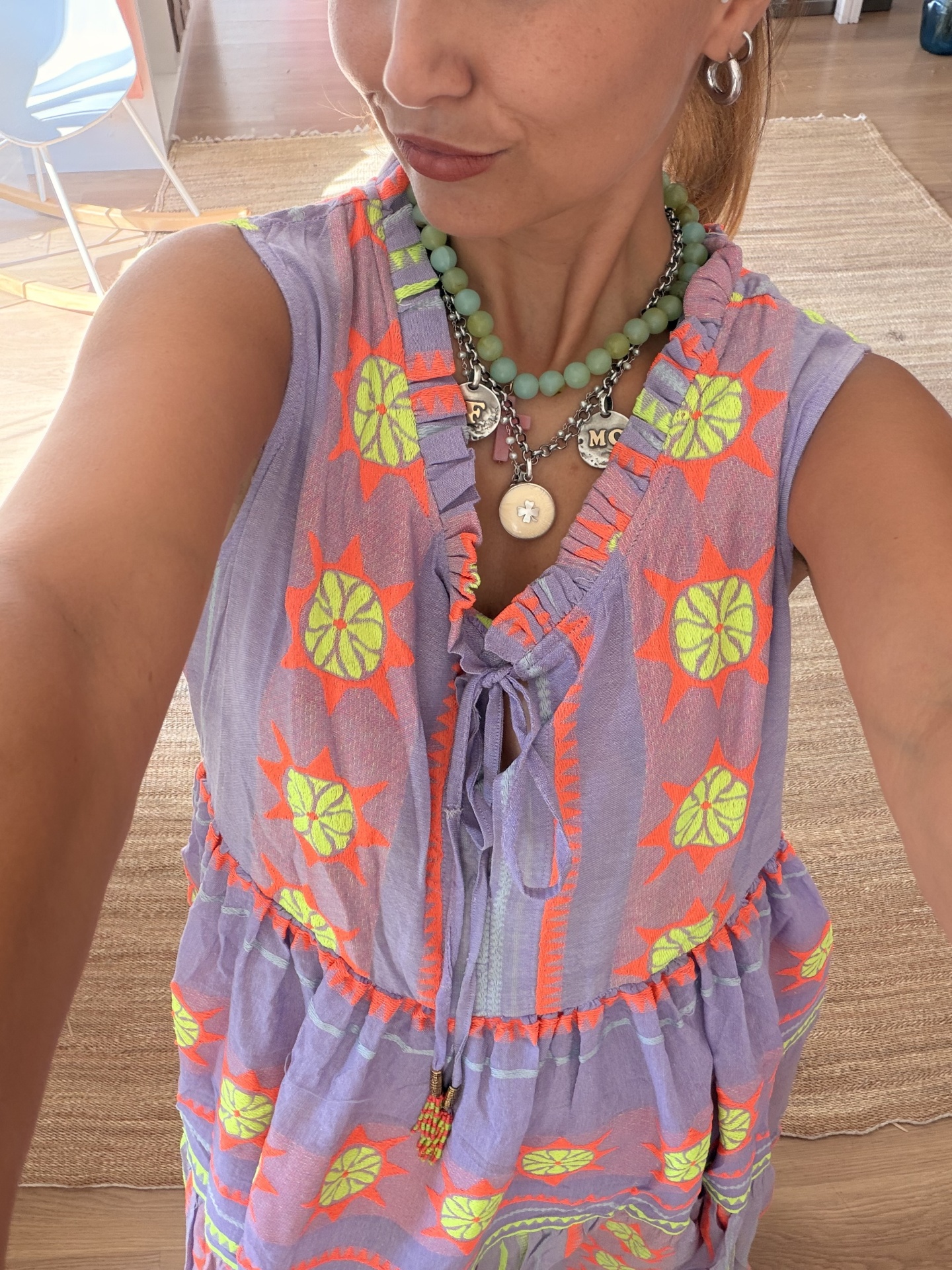 Vestido Boho Chic Fluo Vestido bordado lilás com laço frontal e colares verdes e prateados