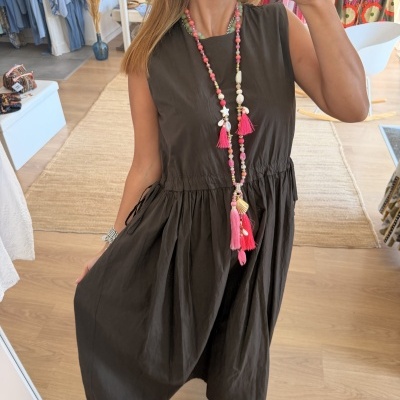 Vestido castanho escuro sem mangas, colar colorido e sandálias prateadas