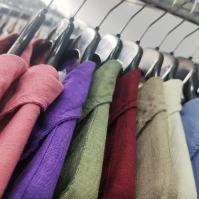 Casacos coloridos pendurados em cabide num cabideiro metálico