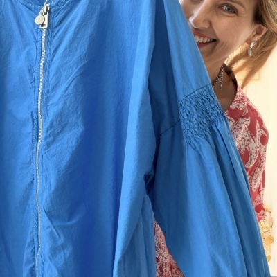 Casaco azul com fecho de correr e detalhe franzido nas mangas