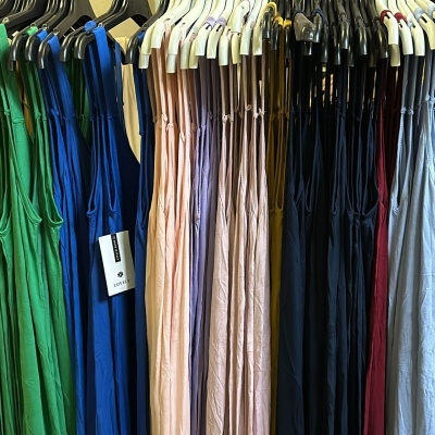 Vestidos coloridos pendurados em cabides sobre um suporte