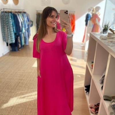 Mulher com vestido rosa fúcsia em loja de roupa