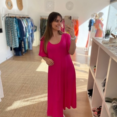 Vestido comprido rosa com mangas curtas bufantes numa loja de roupa