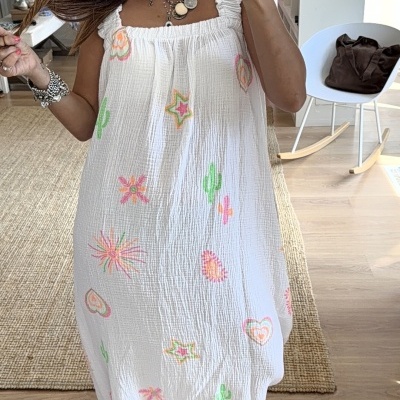 Vestido branco com motivos coloridos em ambiente interior