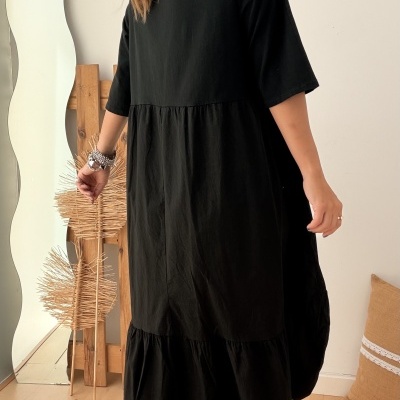 Vestido preto de algodão com folho usado por mulher vista de costas