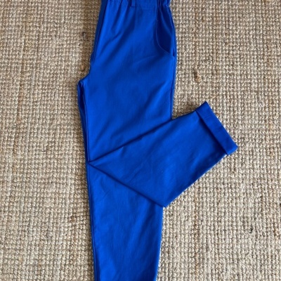 Calças azuis com cintura franzida sobre tapete bege entrelaçado