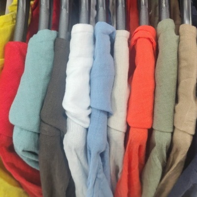 Camisolas coloridas em cabides numa loja