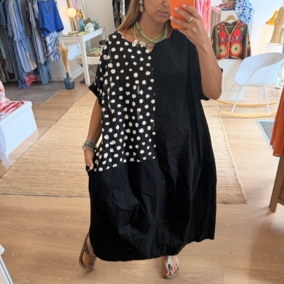 Vestido preto com bolinhas brancas usado por mulher em loja