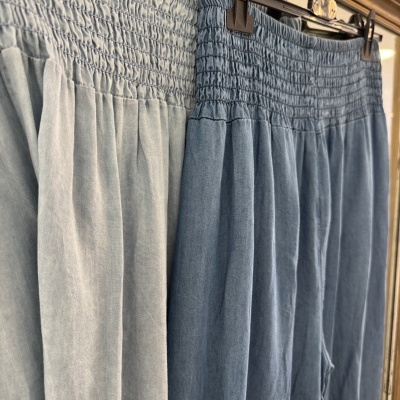 duas saias de tecido azul claro e azul médio com cintura franzida penduradas