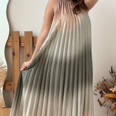Vestido maxi plissado em tons pastel degradê usado por mulher sorridente