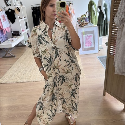 Vestido comprido estampado em loja com mulher a tirar fotografia no espelho
