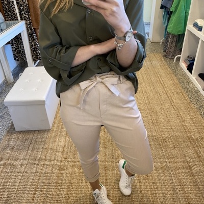 Roupa casual com camisa verde escura e calças bege com ténis brancos