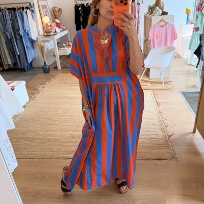 Vestido comprido às riscas laranja e azul num espelho de loja