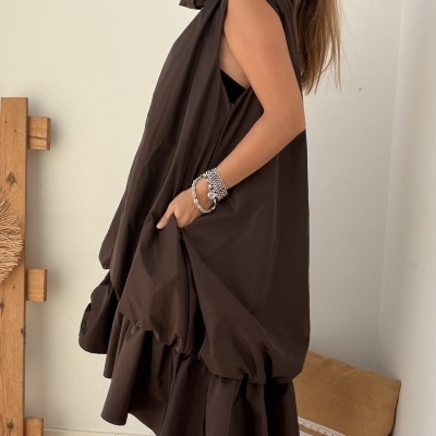Vestido castanho escuro sem mangas com botas castanhas e pulseiras prateadas