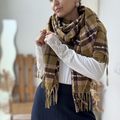 Mulher com lenço xadrez castanho e bege, camisola branca com renda nas mangas e saia preta