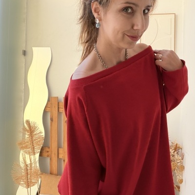 Mulher com camisola vermelha de malha e acessórios prateados