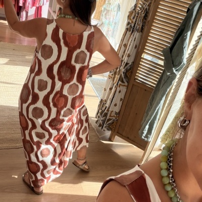 Vestido comprido castanho e bege com padrão abstrato em loja