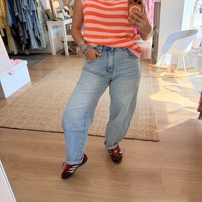 Top de malha com riscas laranja e jeans claros