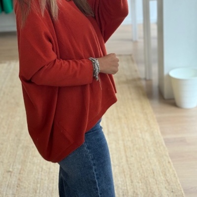 Mulher com camisola vermelha e calças de ganga em loja de roupa