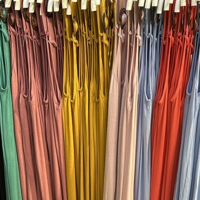 vestidos de várias cores pendurados em cabides numa loja