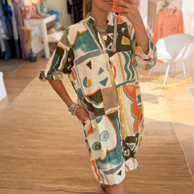 Vestido camiseiro colorido com padrão abstrato em ambiente interior