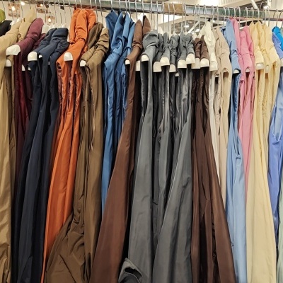 Casacos sem mangas coloridos pendurados em suporte metálico