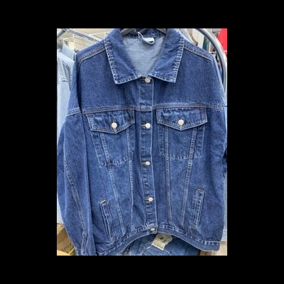 Casaco de ganga azul com botões prateados e bolsos frontais