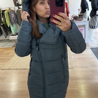 Casaco comprido acolchoado cinza escuro com capuz e fecho assimétrico em loja de roupa