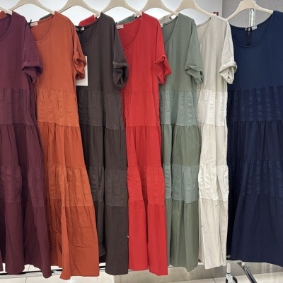 Vestidos coloridos de tecido pendurados numa arara em loja