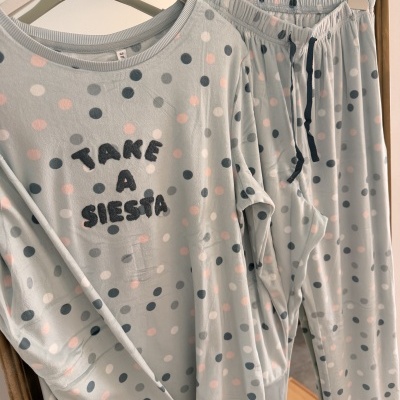 Pijama azul claro com bolinhas e texto TAKE A SIESTA em relevo preto