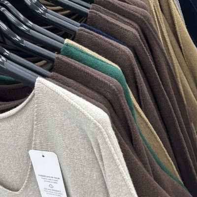 Camisolas em várias cores penduradas em cabides pretos