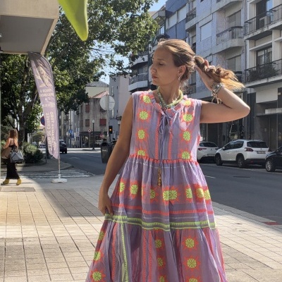 Vestido comprido lilás com padrões florais neón usado por mulher na rua