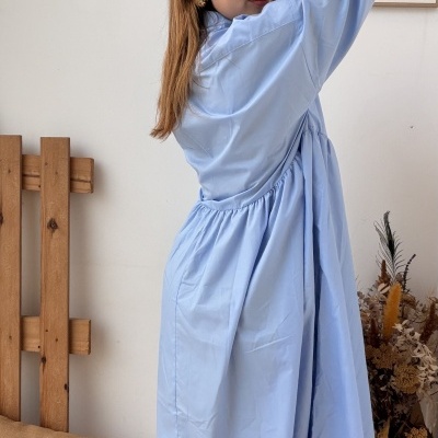 Vestido azul claro com mangas compridas usado por mulher em ambiente interior