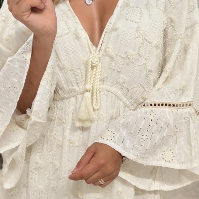 Vestido branco texturizado com mangas largas e cordão com franjas no peito