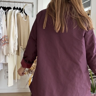 Pessoa de costas com blusão vinho e saia floral vinho no interior