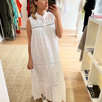 Vestido comprido branco de renda com padrão floral usado por mulher a tirar selfie numa loja