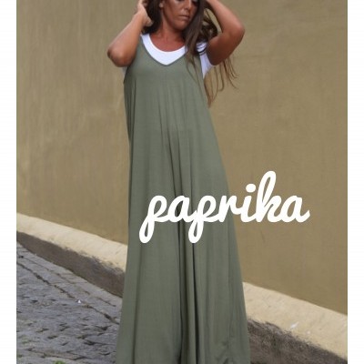 Macacão largo verde com camisola branca em mulher numa rua de calçada